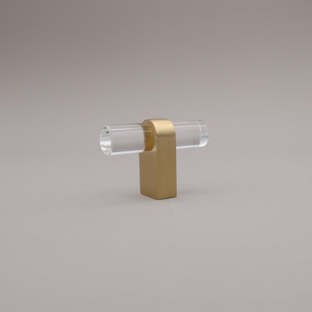 Clear acrylic and satin brass gold stem knob on gray background