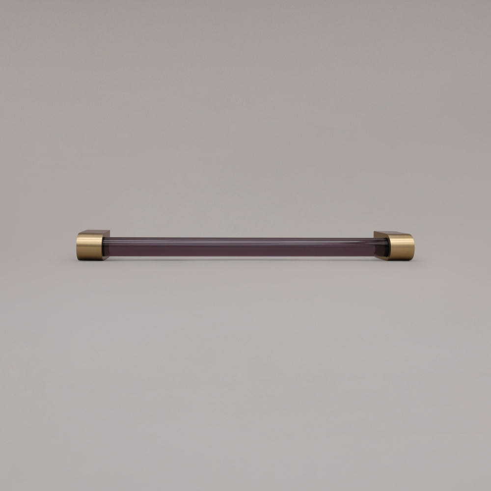 Clarity smoke acrylic and satin brass stems 12 inch appliance pull laying on gray background