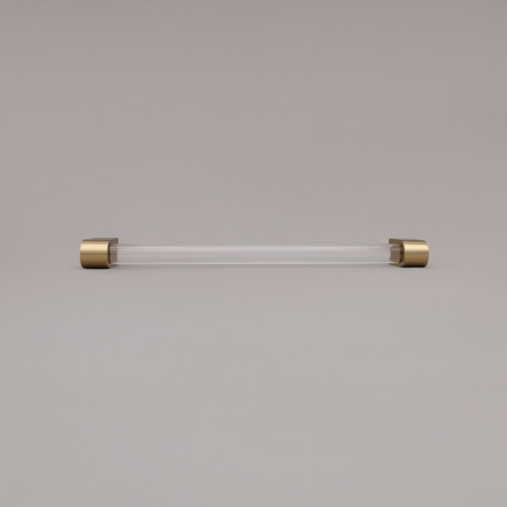 Clarity clear acrylic and satin brass stems 12 inch appliance pull laying on gray background