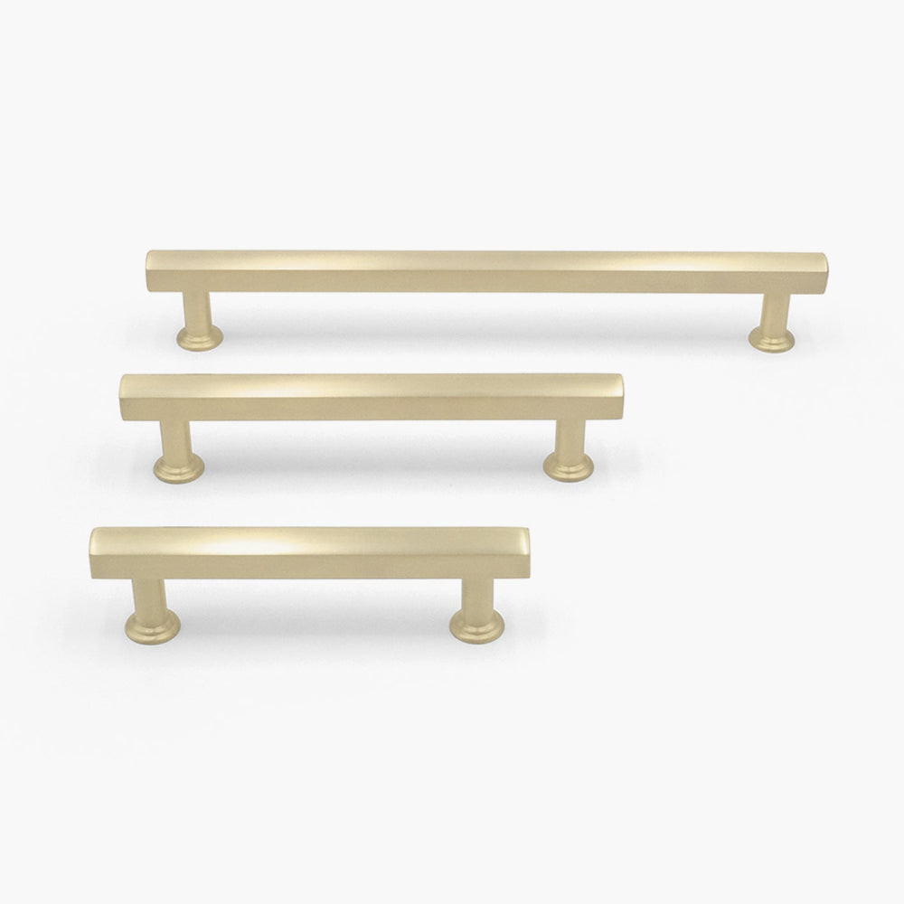 three mod cabinet pulls in satin brass in three sizes on white background