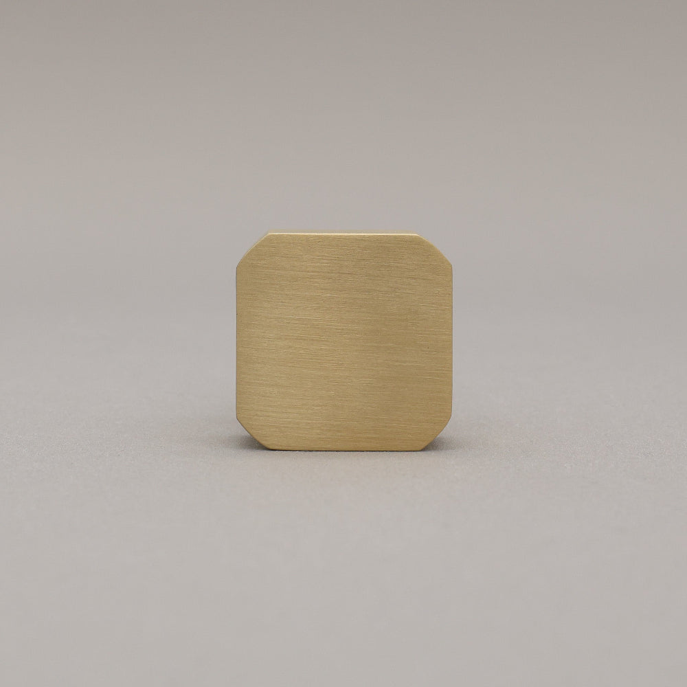 unlacquered satin brass gold square knob on gray background