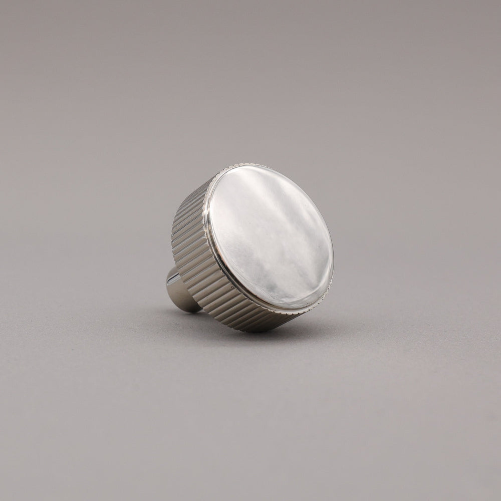 polished nickel textured ribbed knob with fluting detail on a gray background
