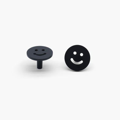 Two Satin Brass Smiley knobs, one standing and one front-facing while laying down