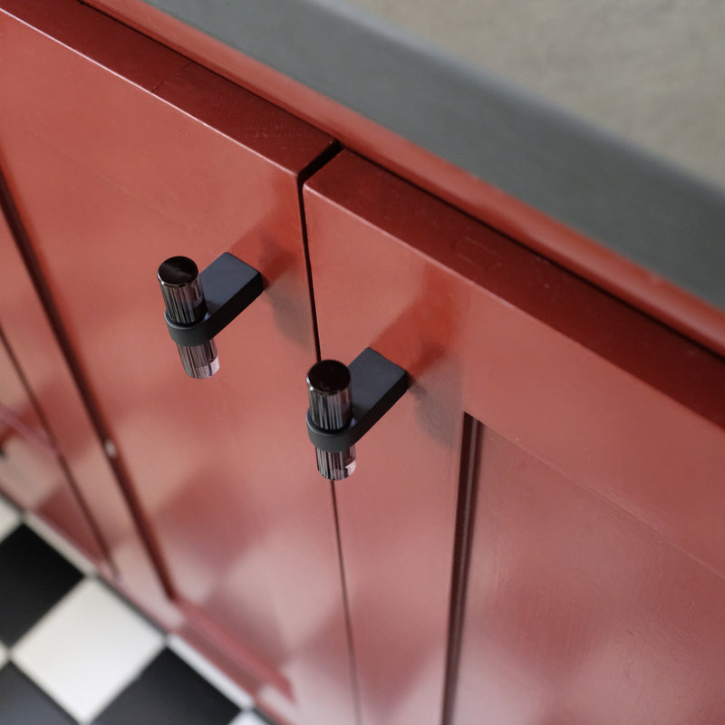 Red bathroom vanity with black designer cabinet knobs 