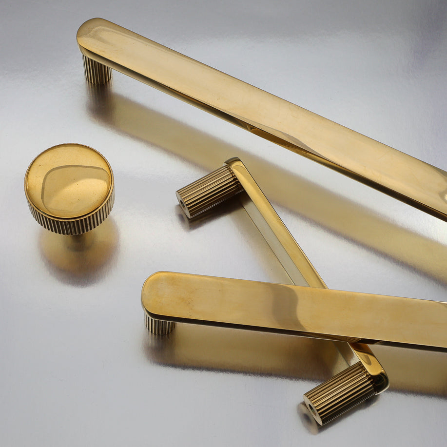 Mix of satin brass knobs and pulls on a dark wood coffee table.
