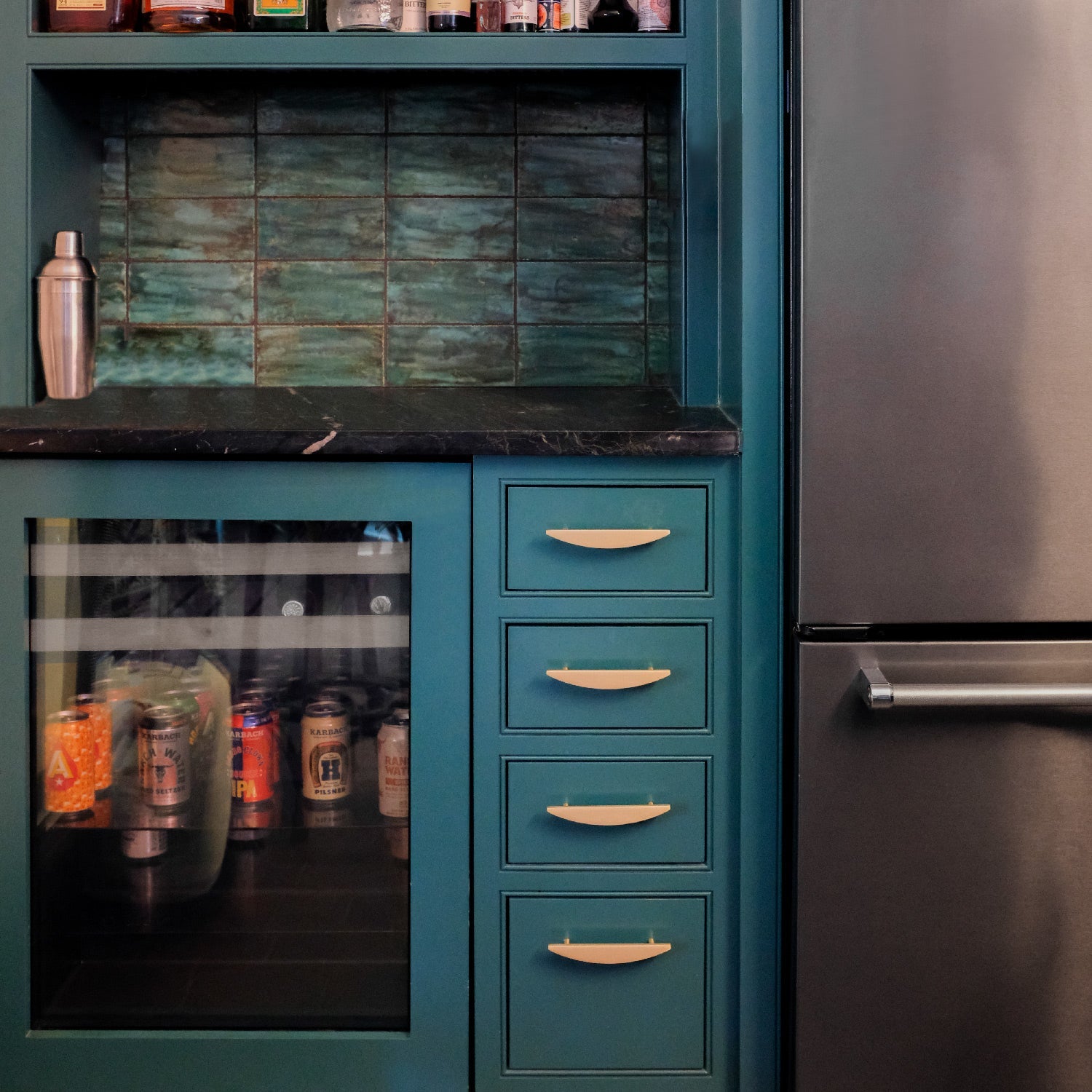 Green mini bar with gold cabinet handles in an Austin home. 