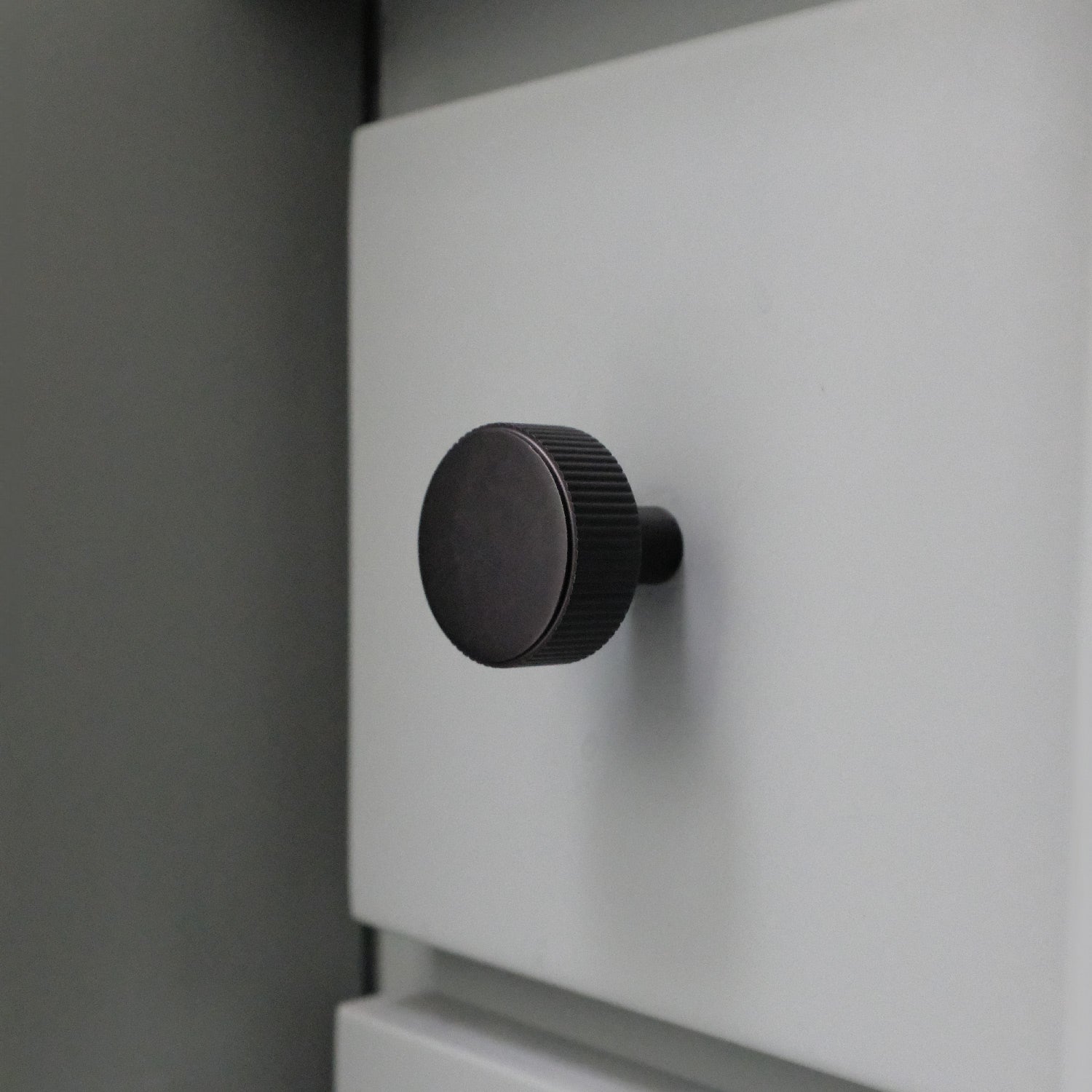 Black Ribbed Cabinet Knob on Blue Drawer