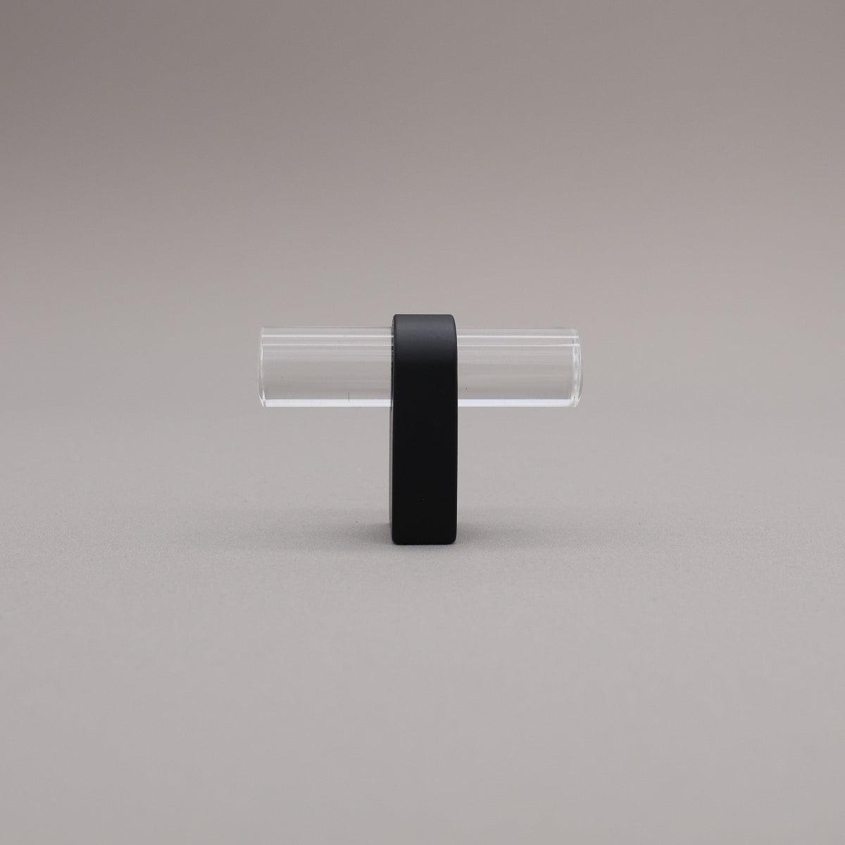 Clear acrylic and matte black stem knob on gray background