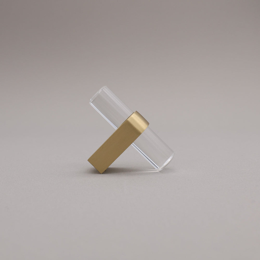 Clear acrylic and satin brass gold stem knob on gray background