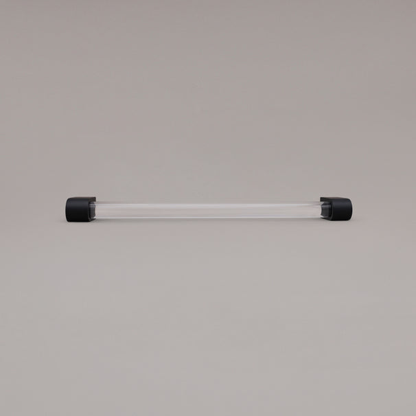 Clarity clear acrylic and matte black stems 12 inch appliance pull laying on gray background