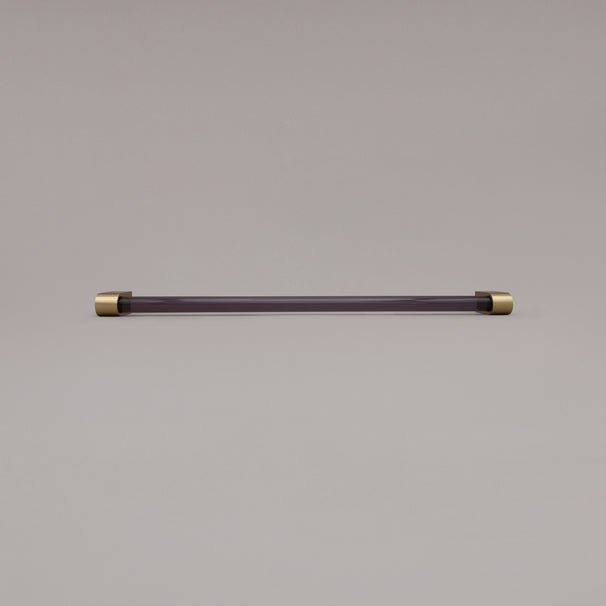 Clarity smoke acrylic and satin brass stems 18 inch appliance pull laying on gray background