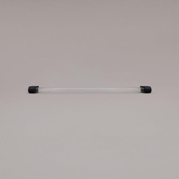 Clarity clear acrylic and matte black stems 18 inch appliance pull laying on gray background