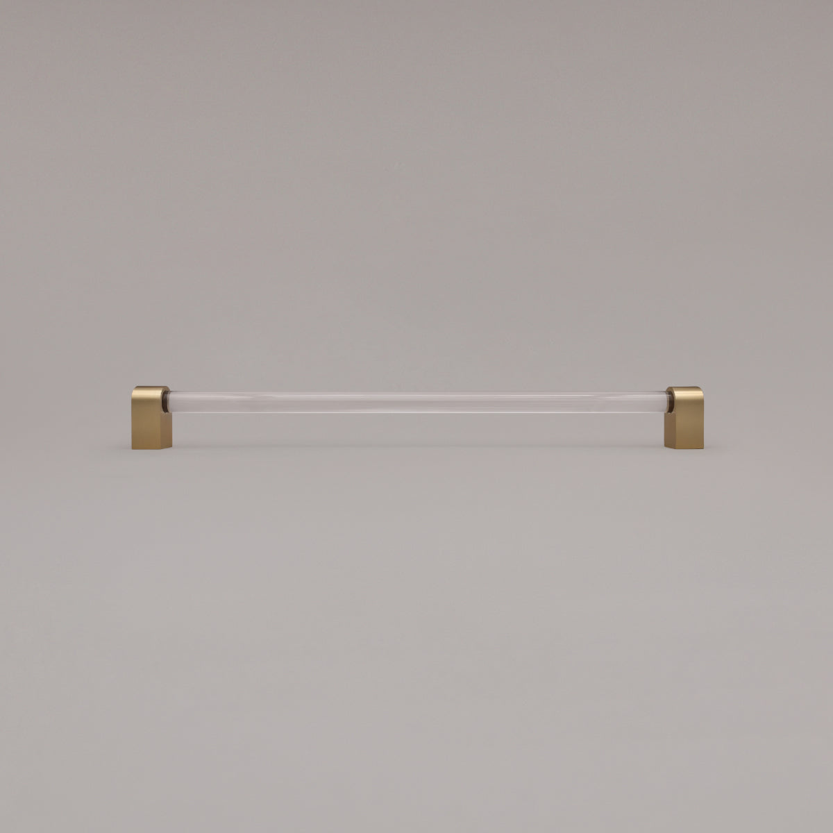 Clarity clear acrylic and satin brass stems 18 inch appliance pull standing on gray background