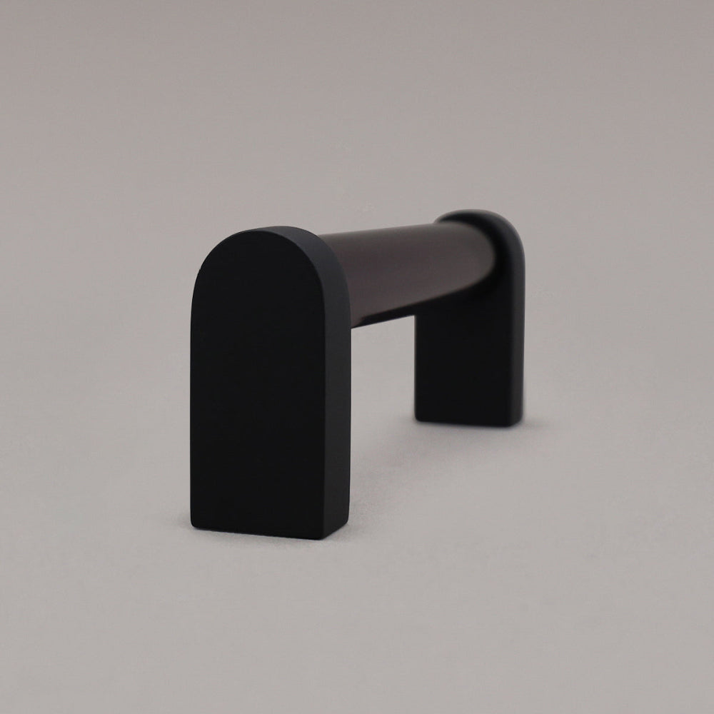 side view of smoke and matte black cabinet pull standing on gray background