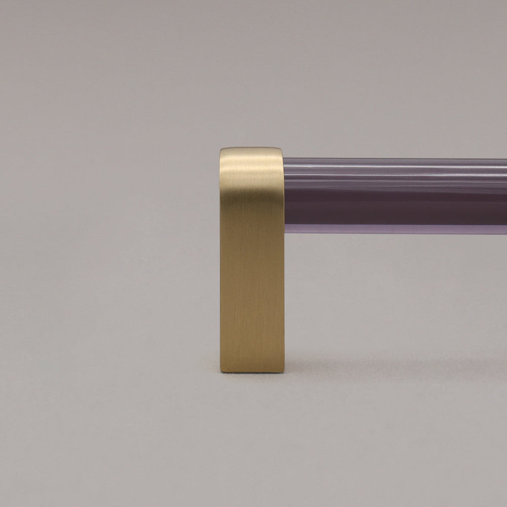 close up of smoke and satin brass cabinet pull stem on gray background