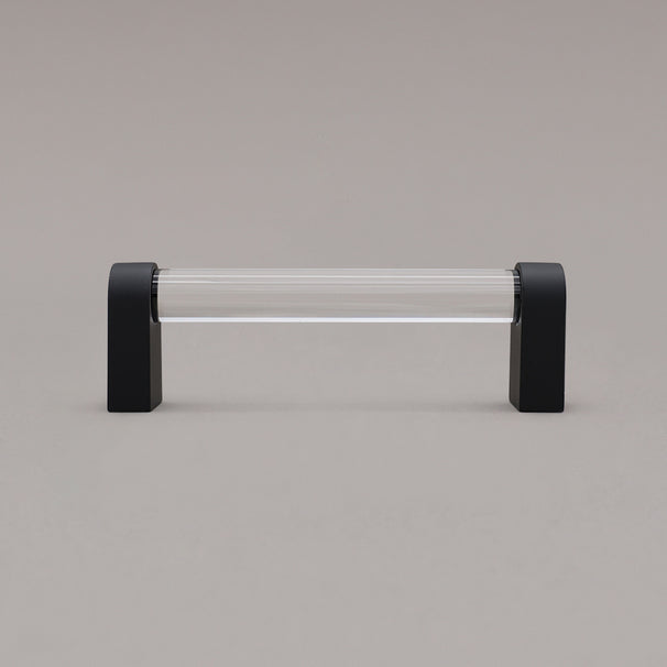 small clear and matte black cabinet pull standing on gray background