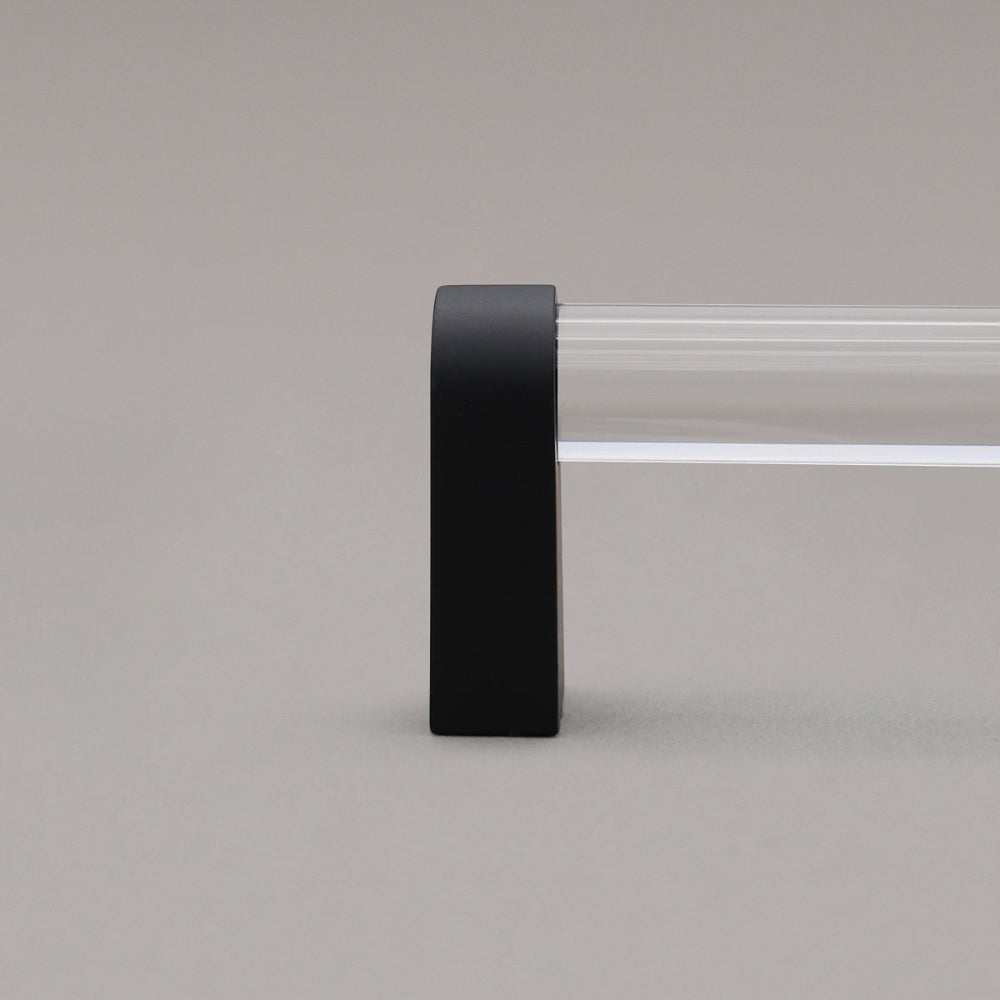 close up of clear and matte black cabinet pull stem on gray background
