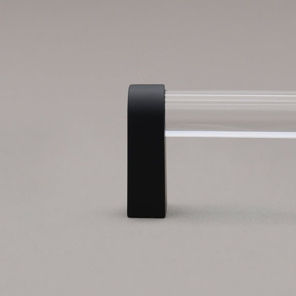 close up of clear and matte black cabinet pull stem on gray background