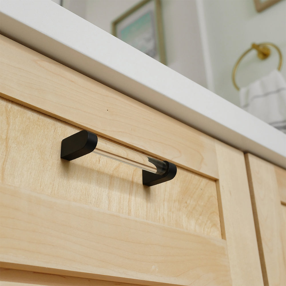 close up of clear and matte black pull on light wood drawer