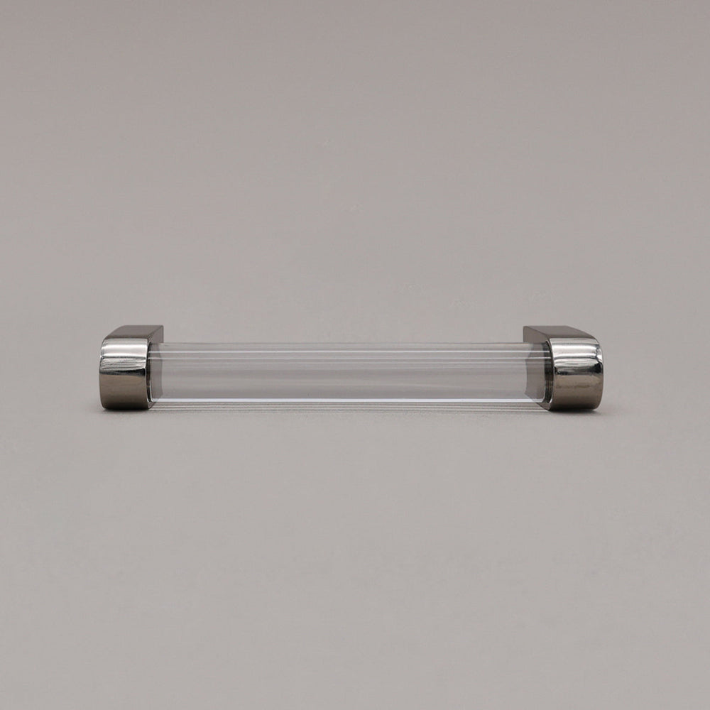 small clear and polished nickel cabinet pull laying on gray background