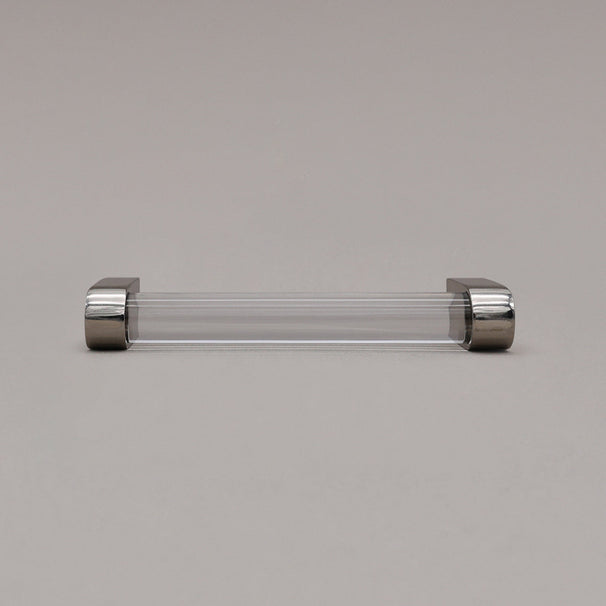 small clear and polished nickel cabinet pull laying on gray background