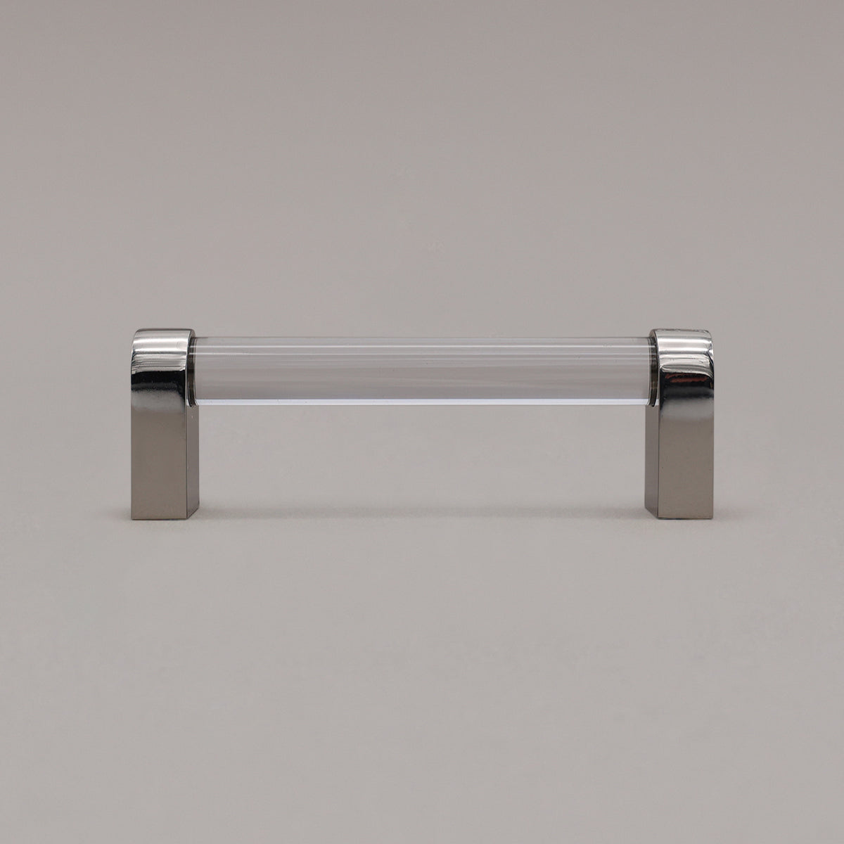 small clear and polished nickel cabinet pull standing on gray background