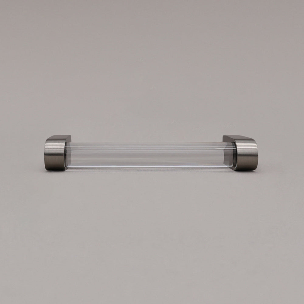 small clear and satin nickel cabinet pull laying on gray background