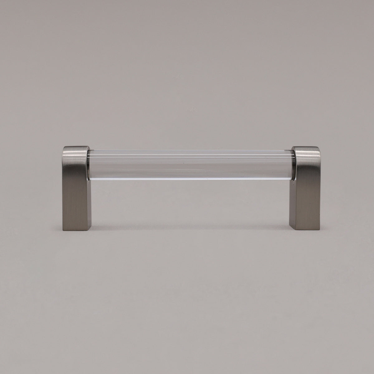 small clear and satin nickel cabinet pull standing on gray background