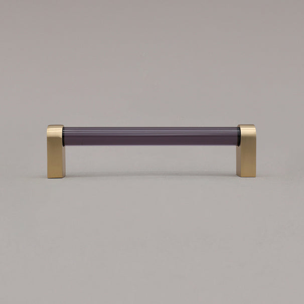 medium smoke and satin brass cabinet pull standing on gray background