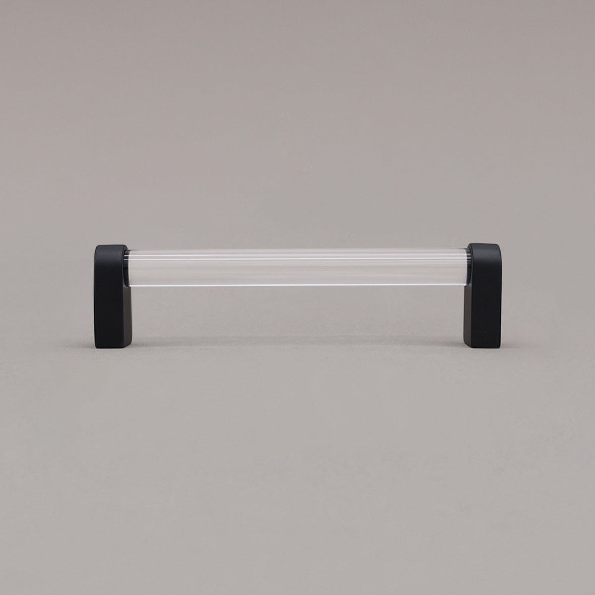 medium clear and matte black cabinet pull standing on gray background