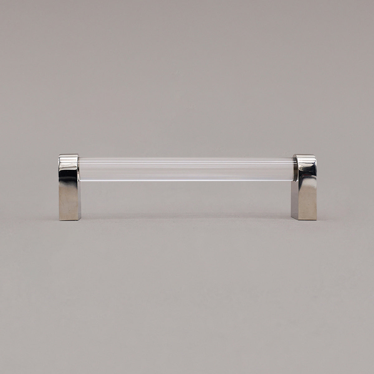 medium clear and polished nickel cabinet pull standing on gray background