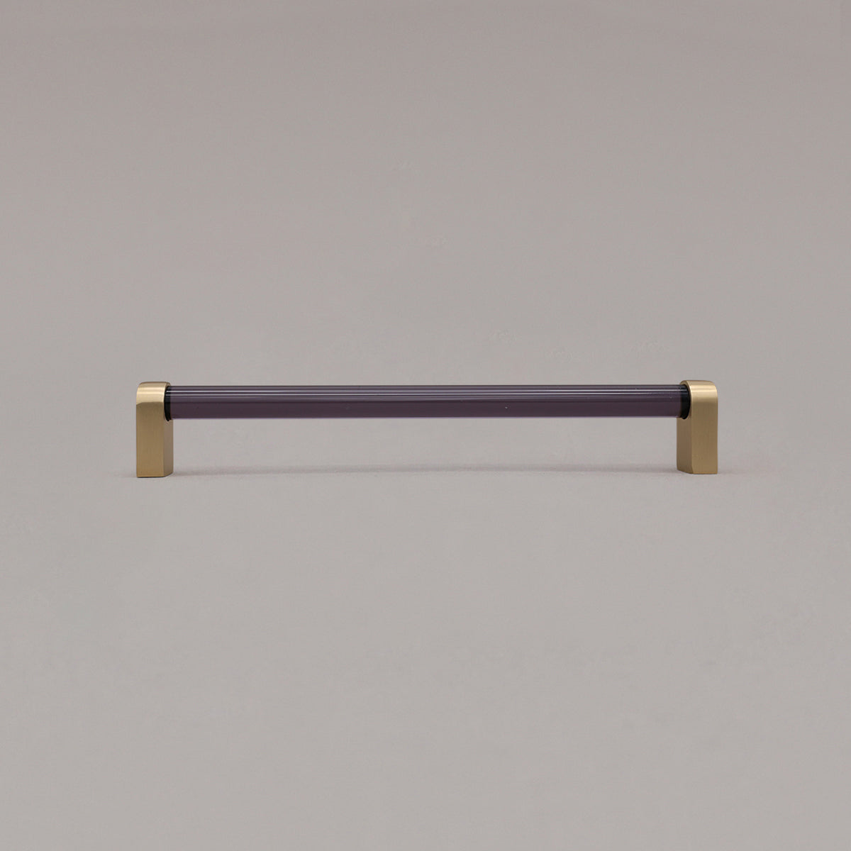 large smoke and satin brass cabinet pull standing on gray background