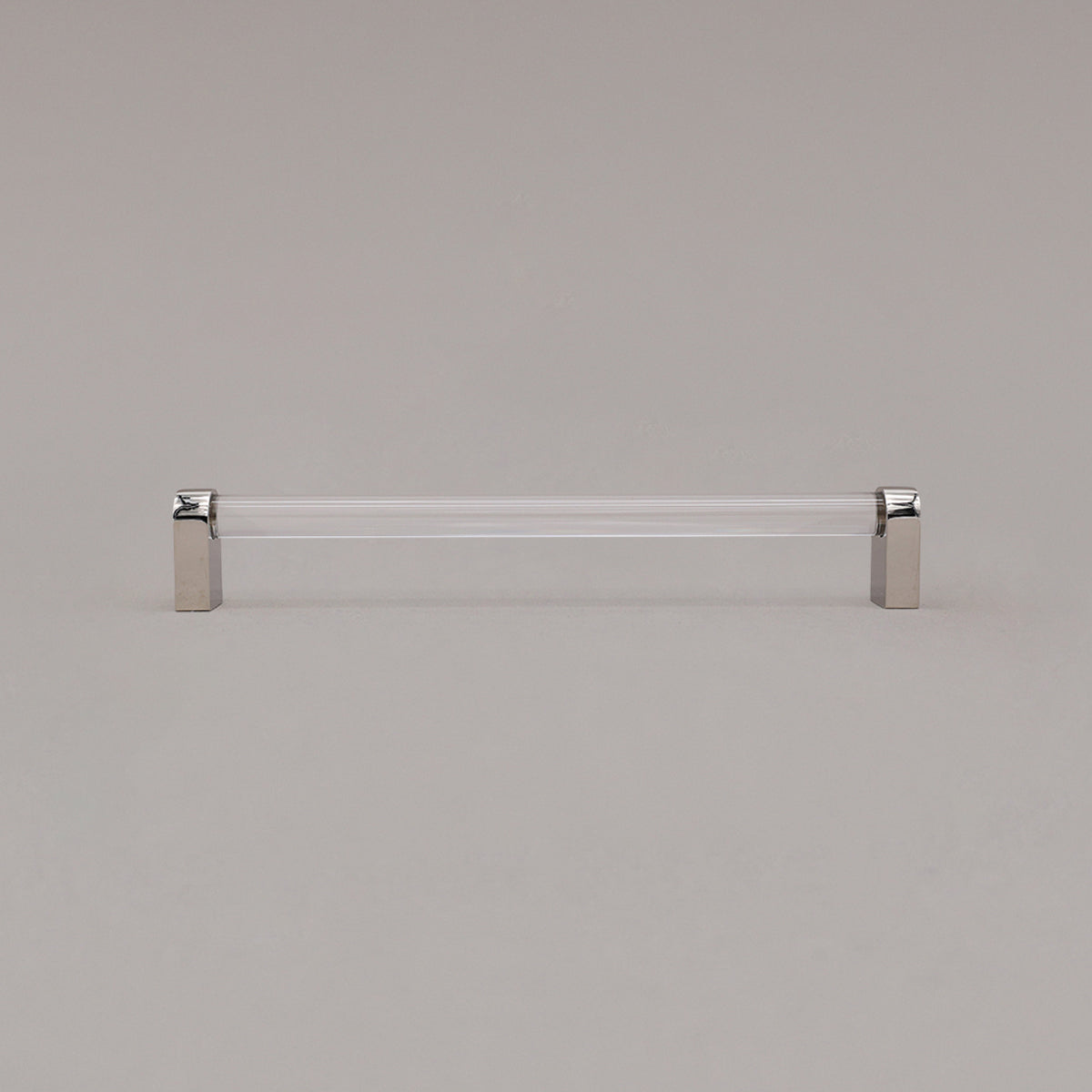 large clear and polished nickel cabinet pull standing on gray background