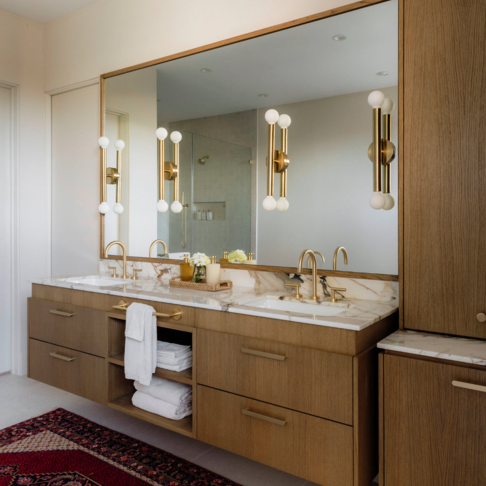 ribbed satin brass cabinet pulls installed in modern bathroom on wooden cabinets