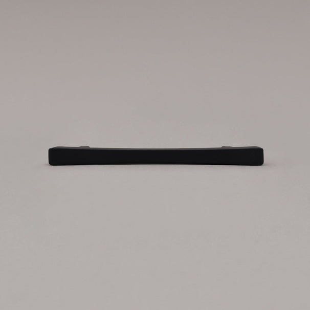 Black cabinet pull laying on gray background