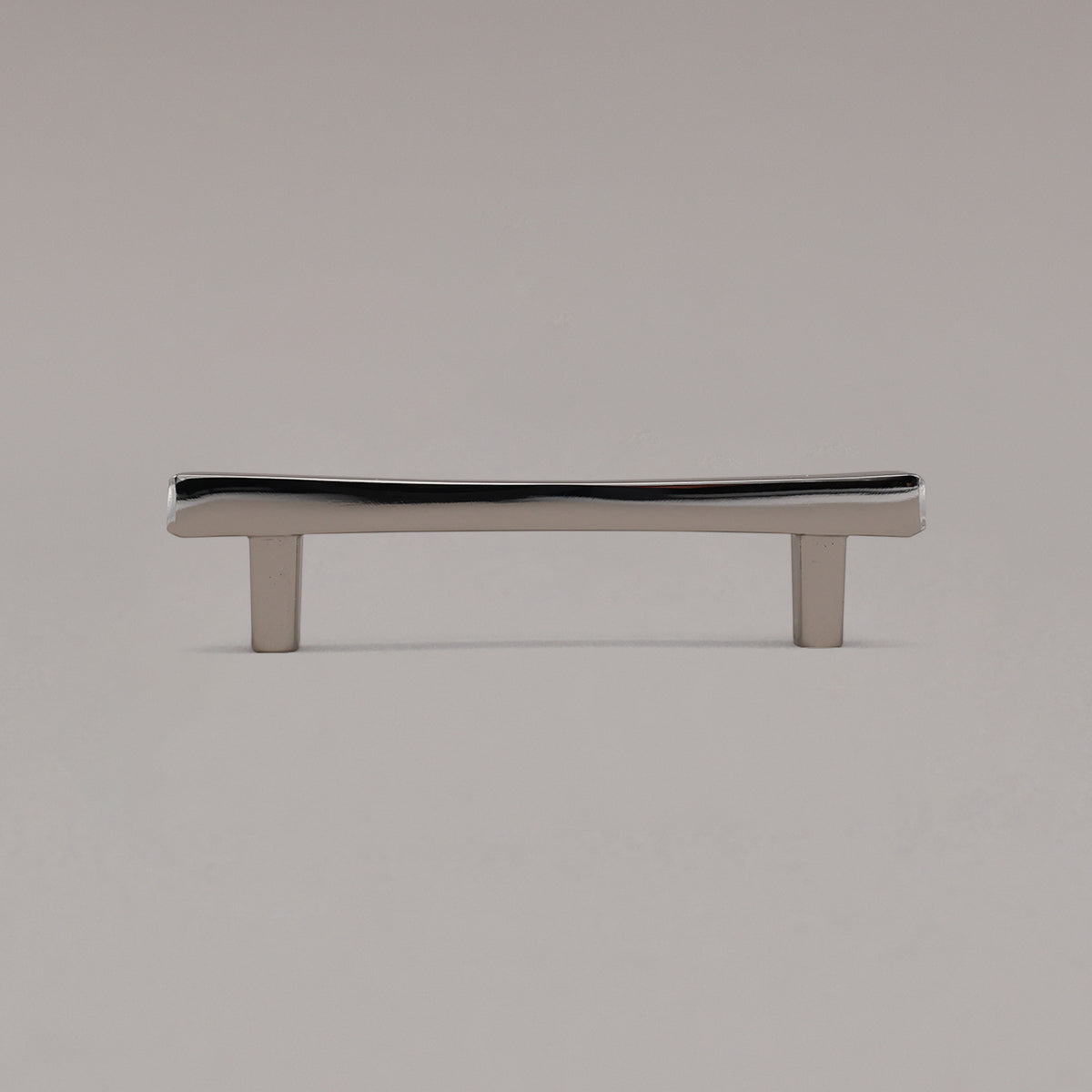 Polished nickel diamond cabinet pull standing on gray background