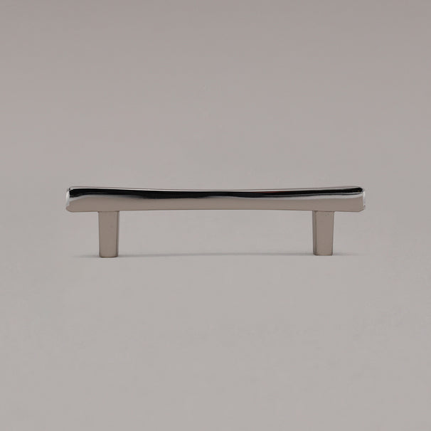 Polished nickel diamond cabinet pull standing on gray background