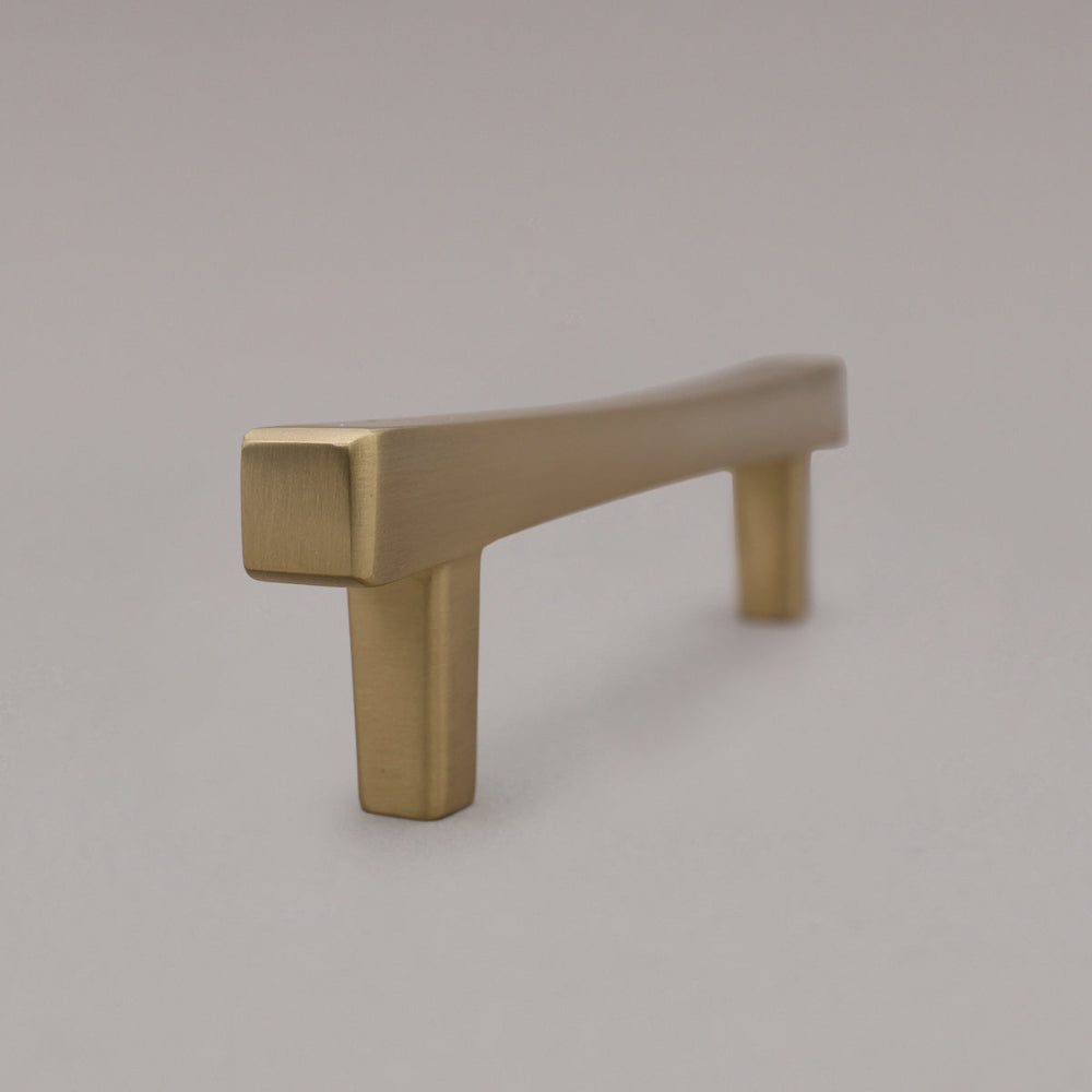 satin brass gold cabinet pull standing on gray background, side view