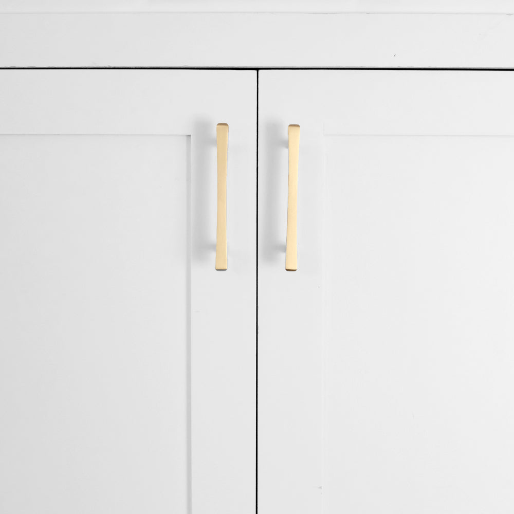 Satin brass gold diamond cabinet pulls installed on white cabinet