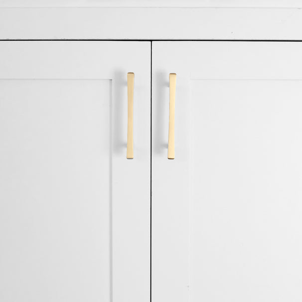 Satin brass gold diamond cabinet pulls installed on white cabinet