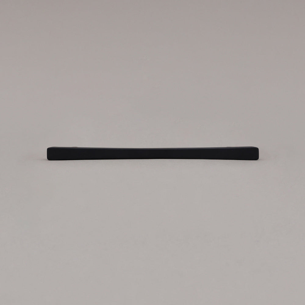 Medium matte black diamond cabinet pull laying on gray background