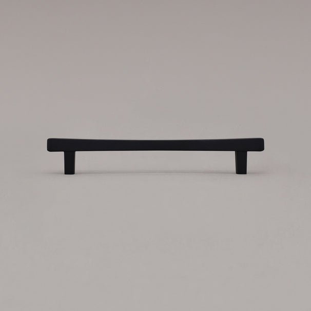 Medium matte black diamond cabinet pull standing on gray background