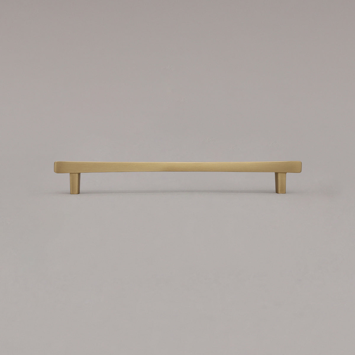 Large satin brass gold diamond cabinet pull standing on gray background