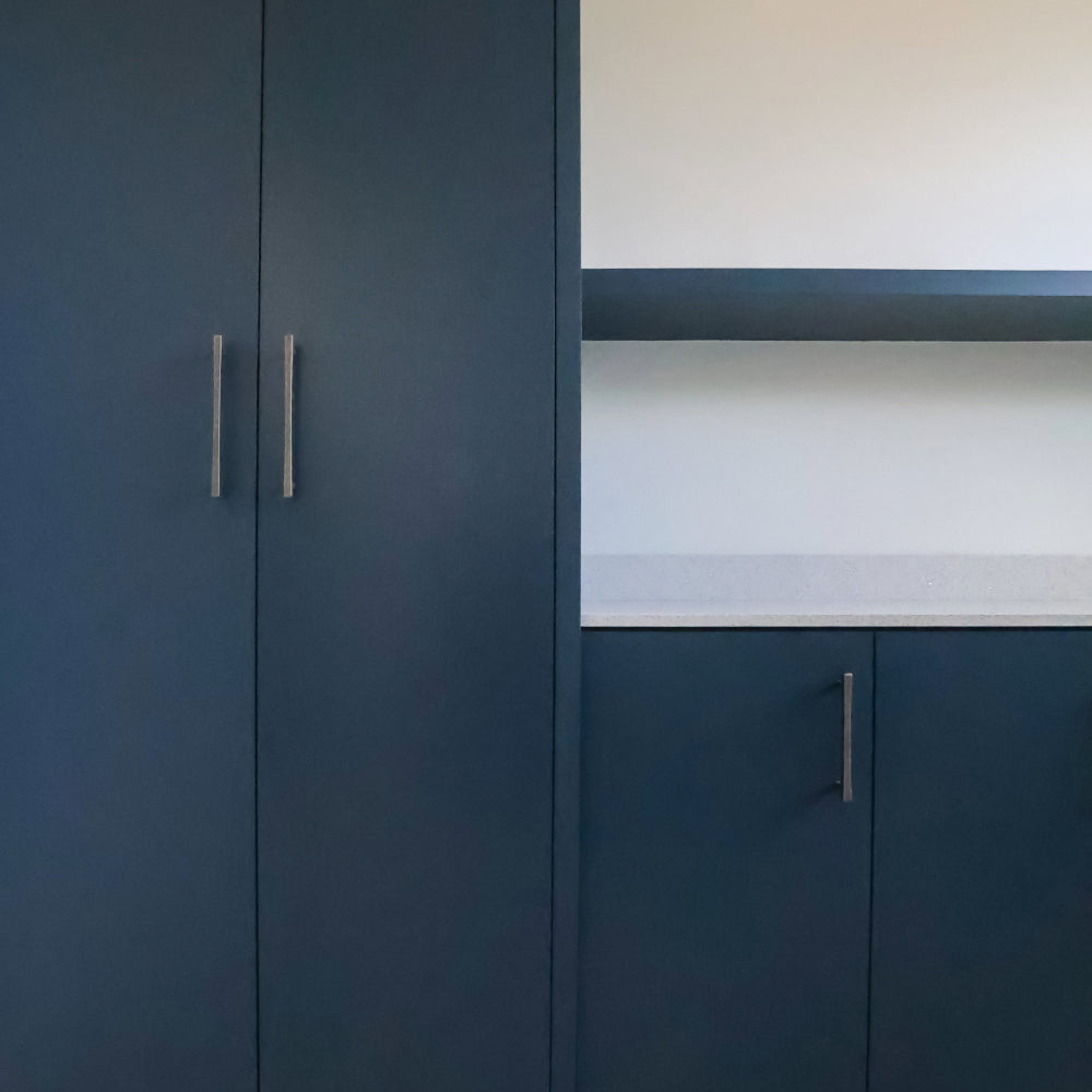 weathered nickel diamond pulls installed on blue cabinets