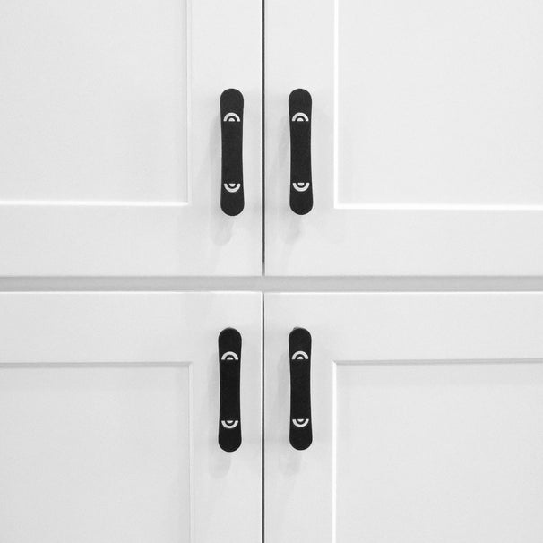 four horizon matte black pulls installed on white cabinets