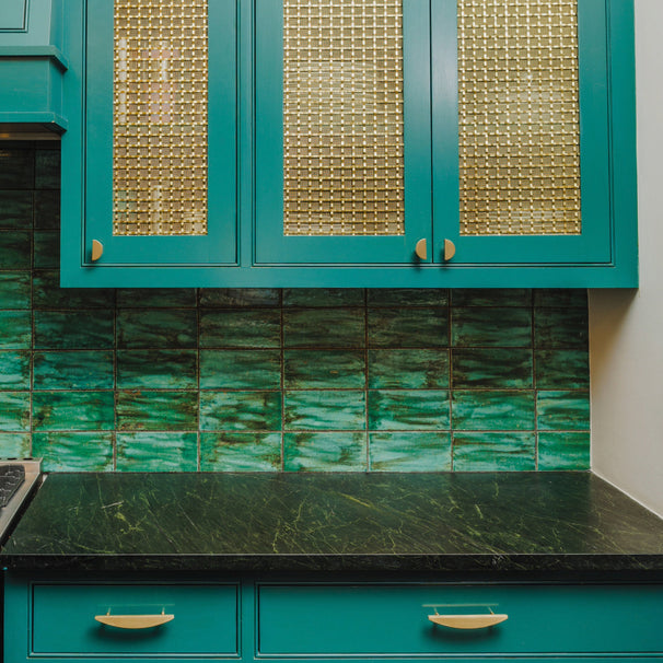satin brass gold half moon pulls and knobs installed on green cabinets