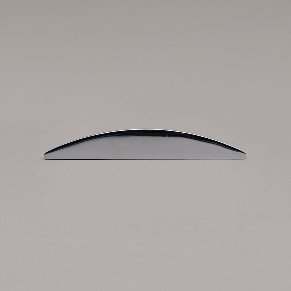 small polished chrome half moon pull laying on gray background