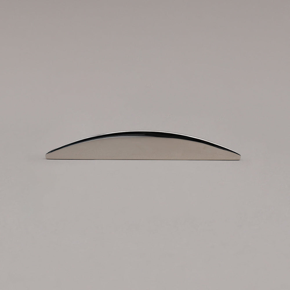 small half moon polished nickel pull laying on gray background