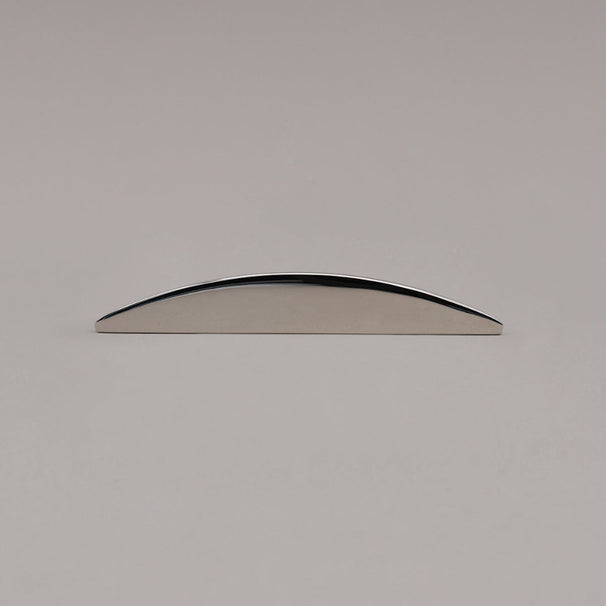 small half moon polished nickel pull laying on gray background