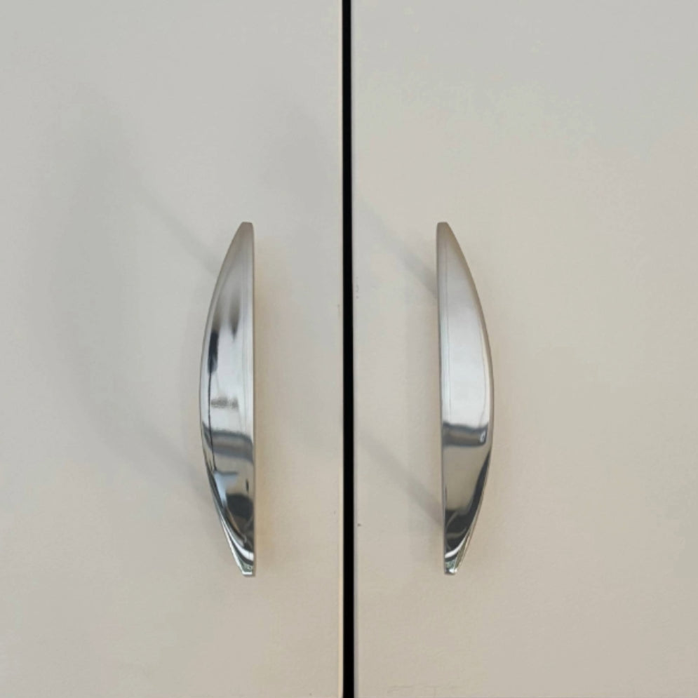 half moon polished nickel pulls installed on white cabinets